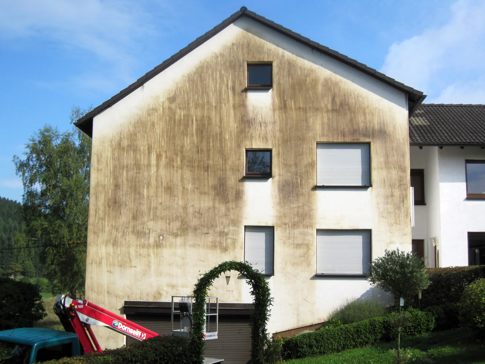 Verschmutzte Putzfassade eines Wohnhauses vor der Reinigung
