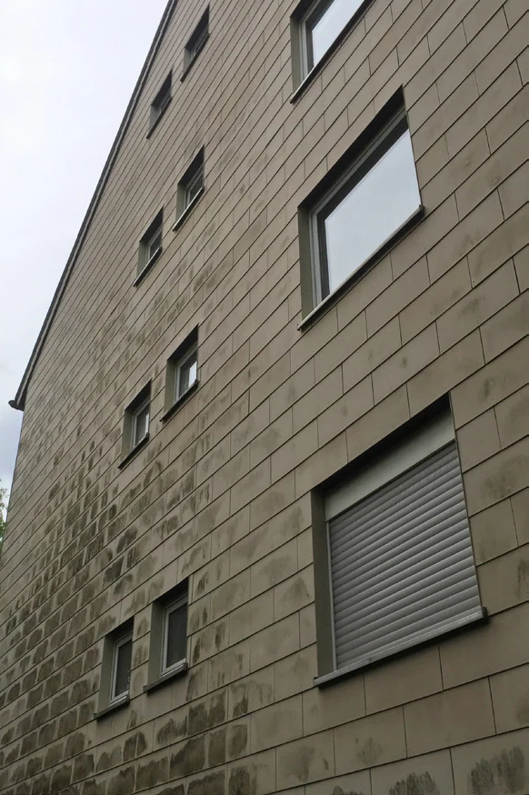 Fassade an einem Wohnhaus vor der Reinigung